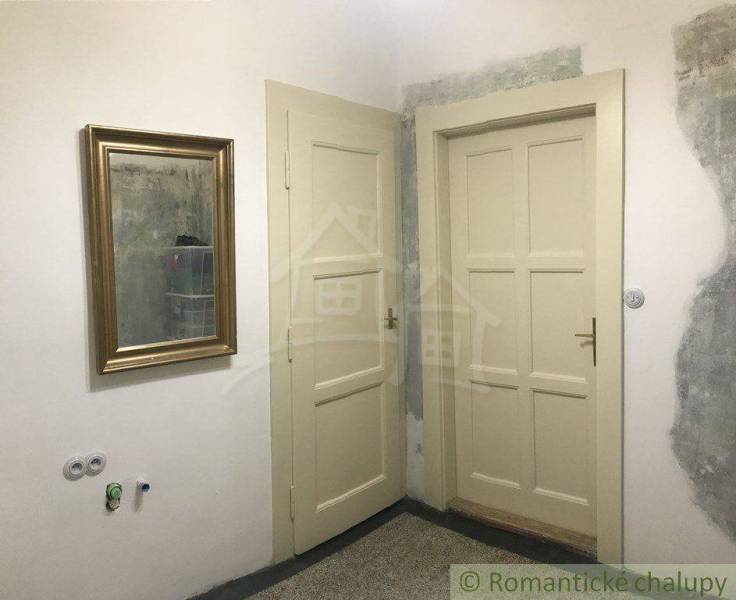 A room with two doors, a golden mirror, ready for renovation. Suitable for a 2-room apartment.