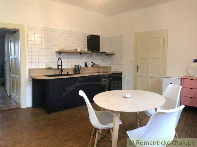 A kitchen in an apartment with wooden furniture and a table for a 2-room apartment for rent.