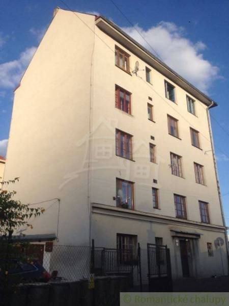 A four-story building with multiple windows offers options for a two-room apartment.