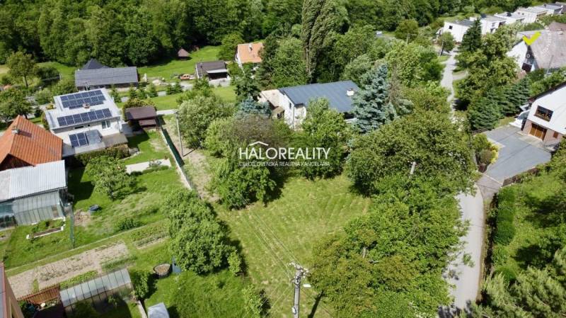 Gardens and family houses in Nová Baňa, surrounded by greenery and trees.