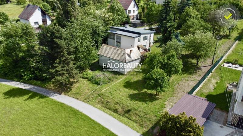 A family house in Nová Baňa surrounded by greenery and enclosed by a garden.