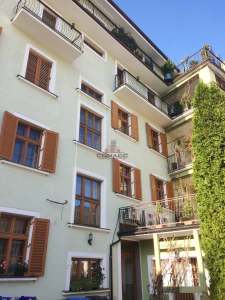 Of course! I see a building with balconies and shutters, dominated by a green facade.