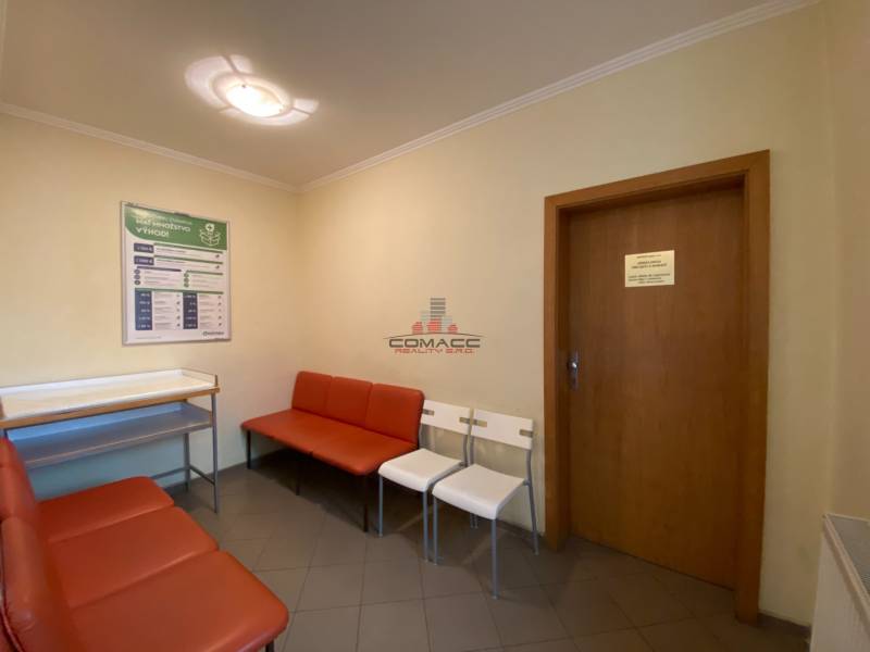 Waiting room with red seats on Nitrianska street, entrance to the office, information board.