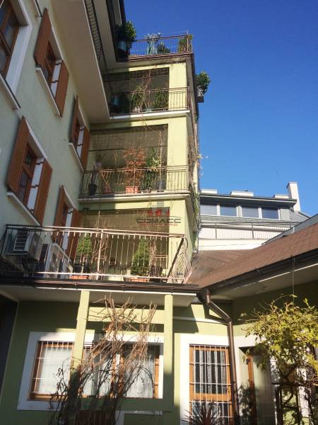 A building with greenery on balconies, Nitrianska street, office spaces under the blue sky.