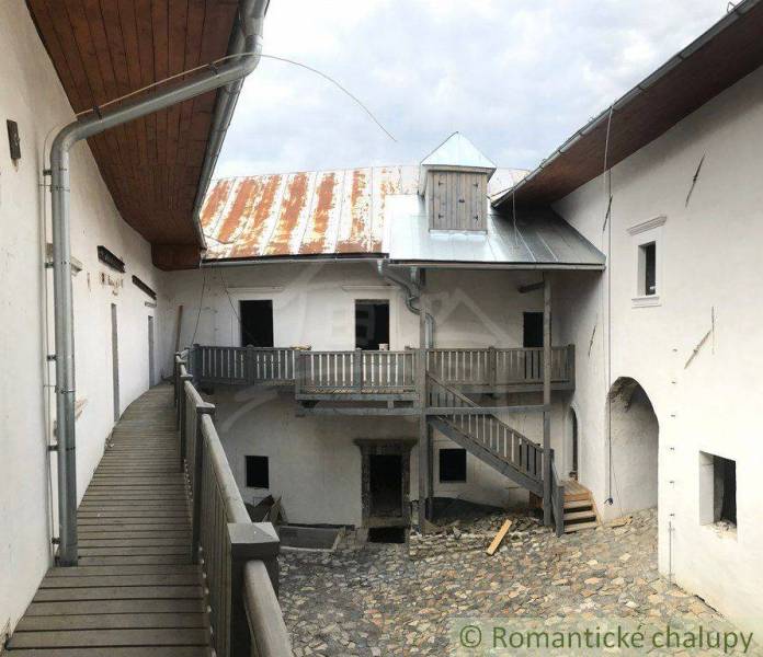 Stone courtyard with wooden railing, metal roof, peculiar properties.