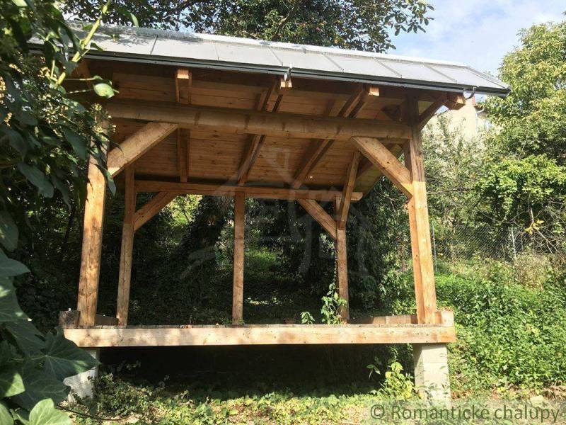 A wooden shelter in the garden, surrounded by nature, with a unique property in the countryside.