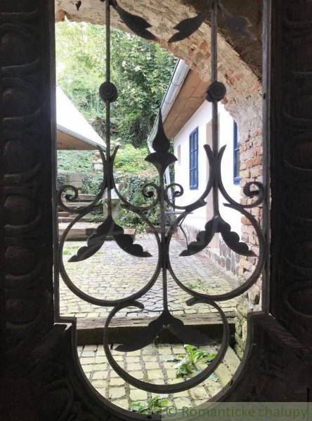 Stone courtyard with a brick wall, decorative grilles, unique properties, romantic cottages.