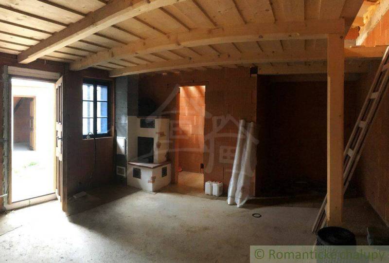 Rustic interior of the house with entrance doors and a sturdy wood stove. Unique property.