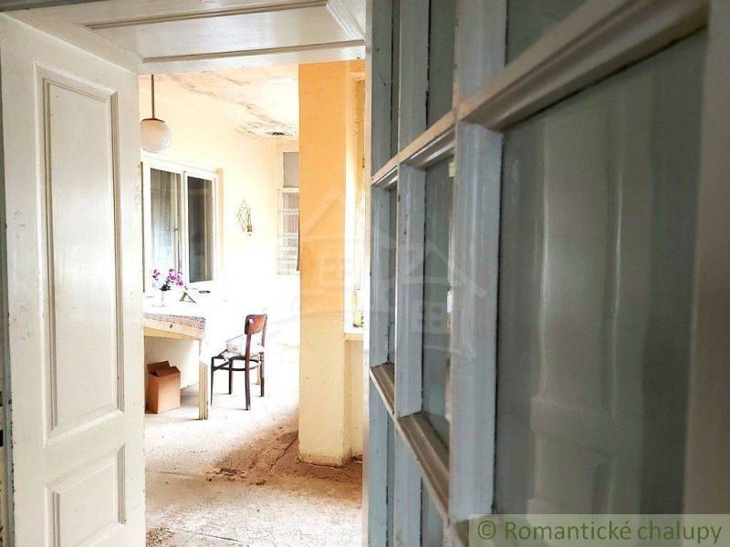 Interior with wooden doors, a flower table, and yellow walls at the cottage.