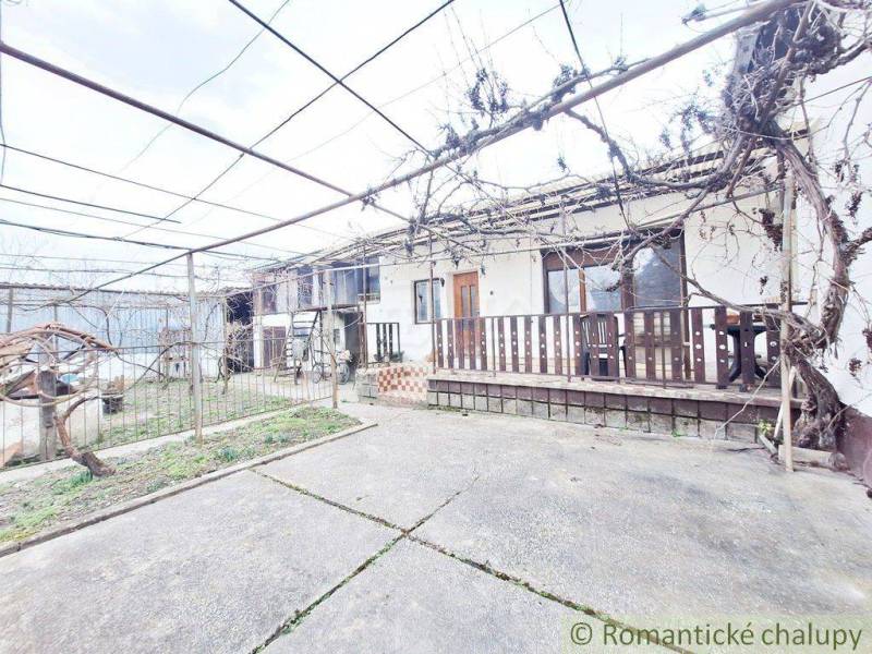 A courtyard with a concrete surface, a pergola, and a family house, ideal for a family.