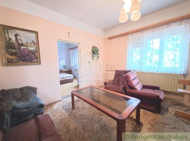 Living room of a family house with a painting and comfortable armchairs, connected to the bedroom.