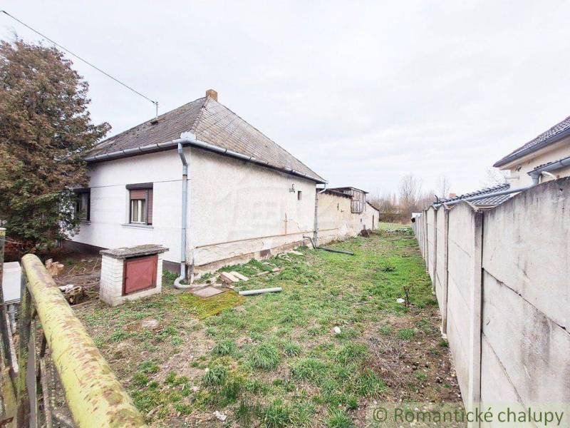 Family house with a garden, fence, tree, and grassy plot in a quiet location.