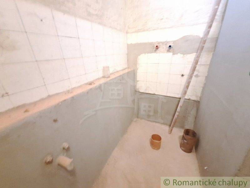 A small cottage with an unfinished bathroom, visible tiles and reconstruction work.
