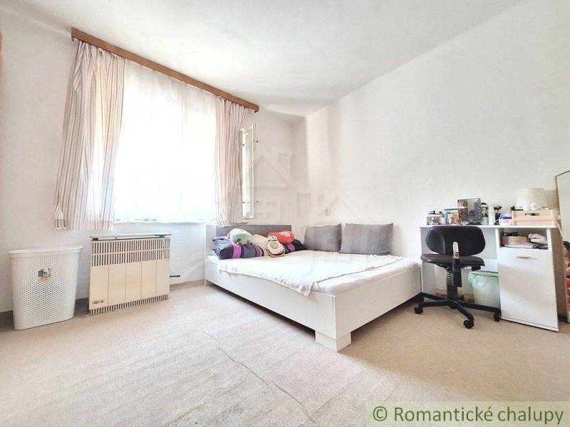Bedroom in a family house with a bed, a desk, and Scandinavian decor.