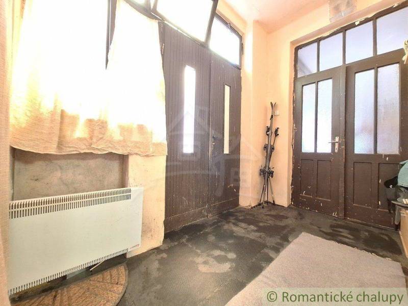 Entrance hall with large doors, curtains, and skis, located in a family house.