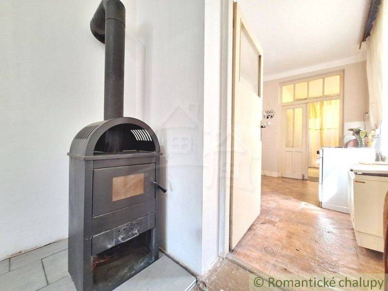Family house with a fireplace, a walkthrough room, and doors leading to a bright kitchen.