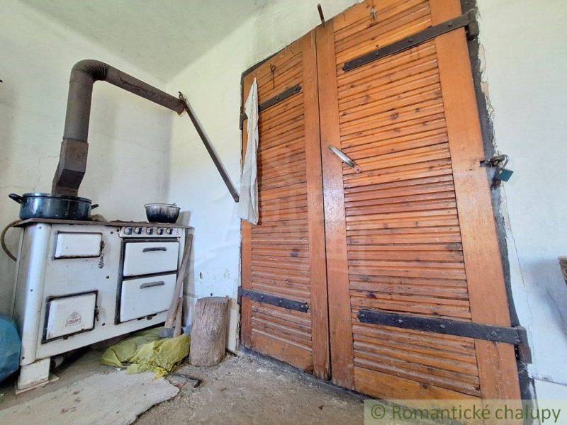 An old tiled stove and wooden doors in a rustic room, Unique properties.