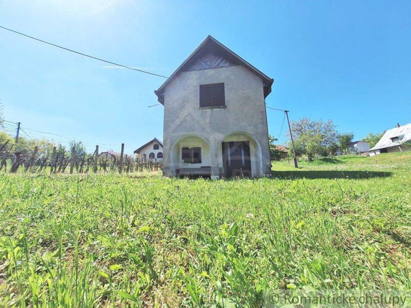 A building on a slope with grass and fencing in the city of Komárno, peculiar properties.