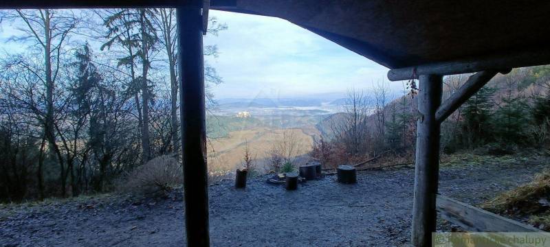 A view from the shelter to a picturesque winter landscape with a family house in the valley.