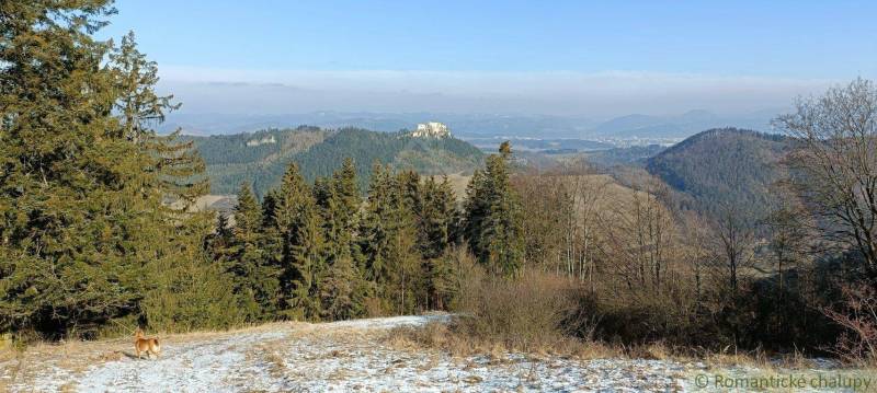 Snow-covered landscape, forest, stunning view of rocks, and visible nature around.