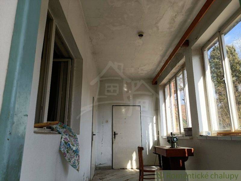A place in a rural family house with a hallway and a sewing machine by the window.