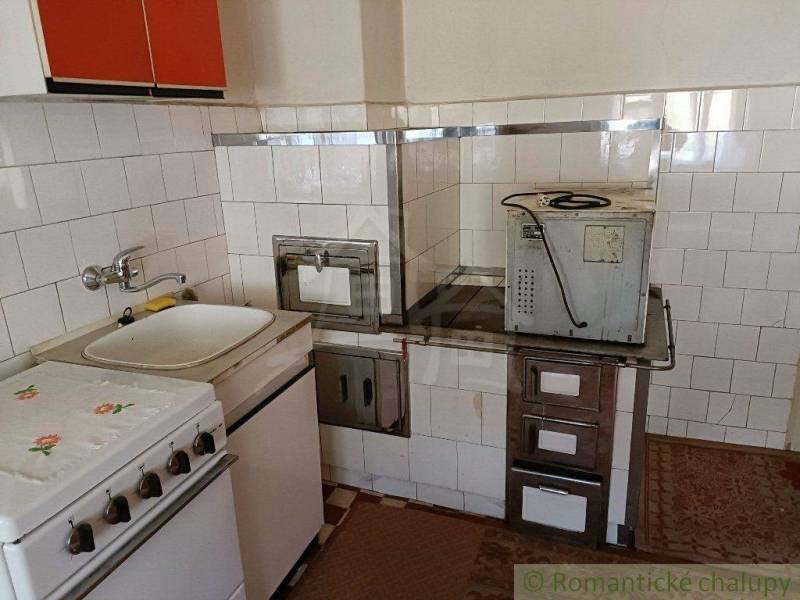 A vintage kitchen with a traditional stove and sink; an ideal place in a cottage.
