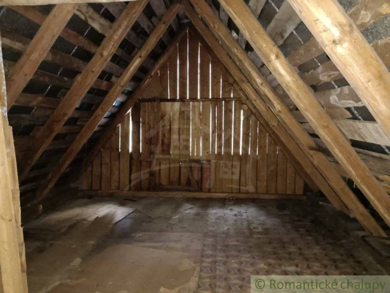The attic of the cottage with wooden beams, a natural atmosphere, the place exudes coziness.