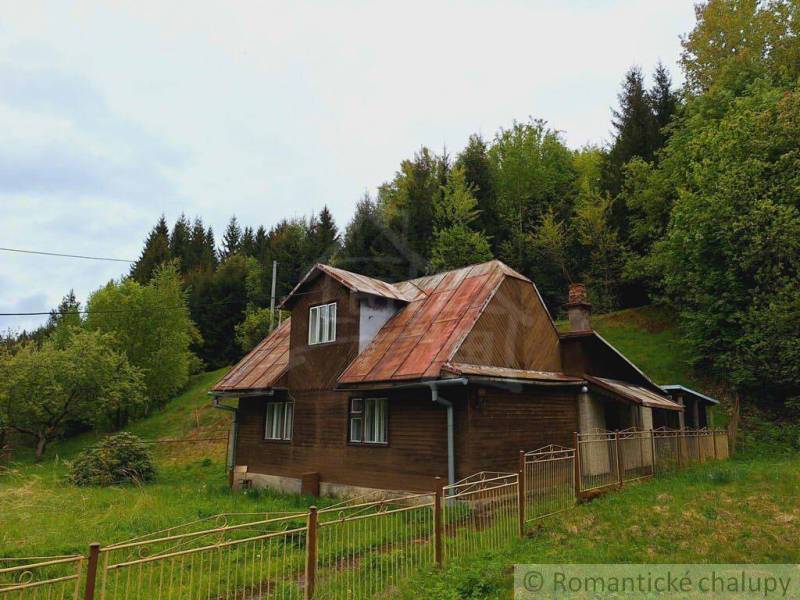 A cottage in Veľké Rovné, surrounded by greenery and forest, simple architecture.
