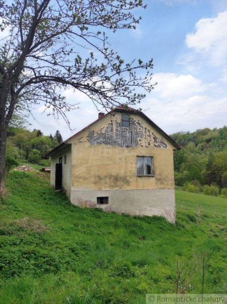 An old cottage with damaged plaster in a picturesque natural setting, an ideal family home.