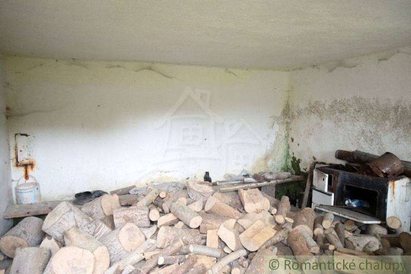 A pile of wood and an old stove in the room of an old family house cottage.