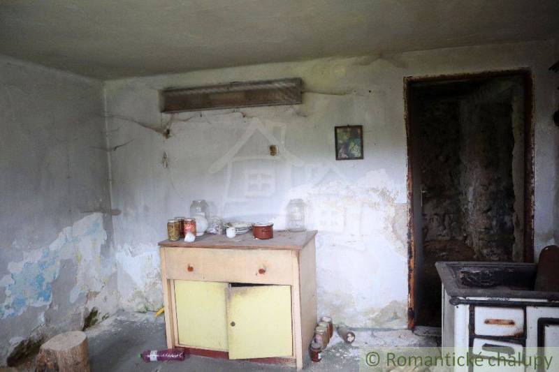 In the room of the family house, there is old furniture and kitchen appliances in need of repair.