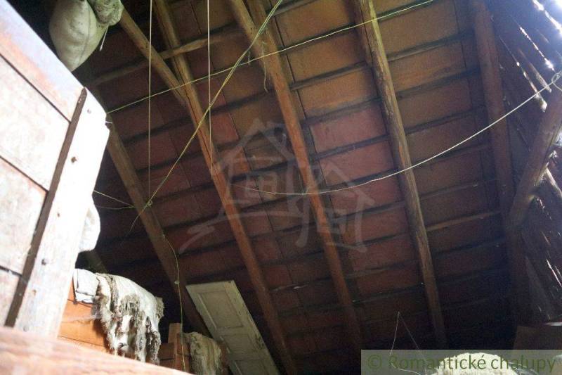 The attic of a family house with an old wooden roof structure and hanging ropes.