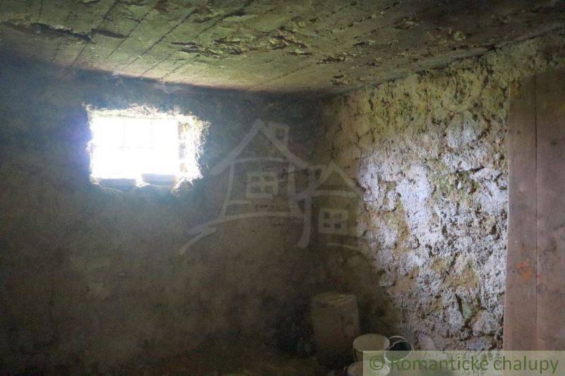 A cellar with old walls, a small window, light penetrates, part of a family house.