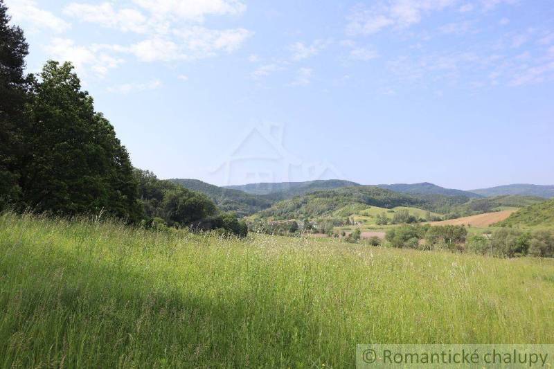 Beautiful nature with hills, valleys, and a family house on the horizon, ideal for relaxation.