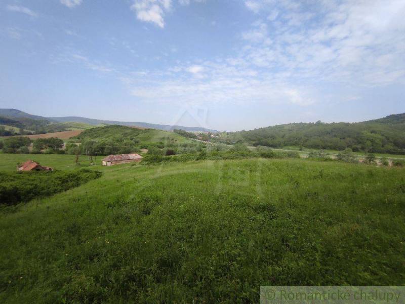 Hills and meadows, a family house, beautiful countryside with a blue sky.