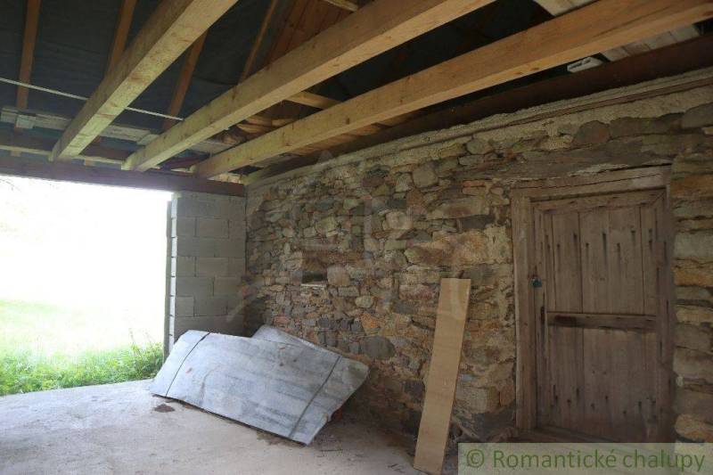 Interior of a building with a stone wall, wooden ceiling, and concrete floor. Family house.
