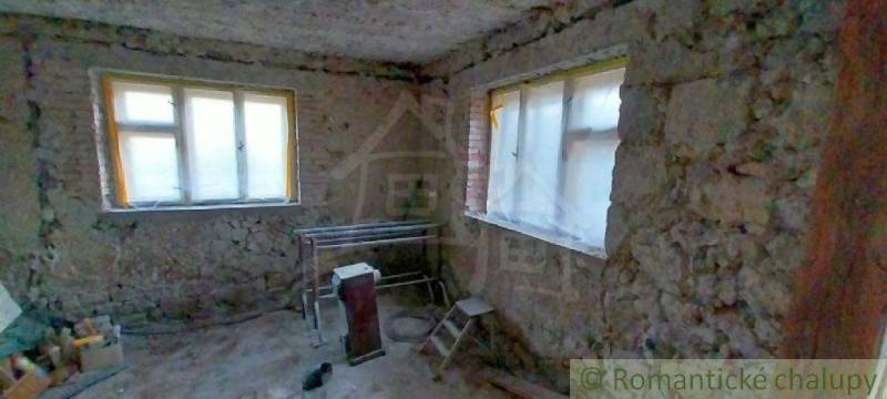 Interior of a house with stone walls, windows, and built-in equipment. Family house for renovation.