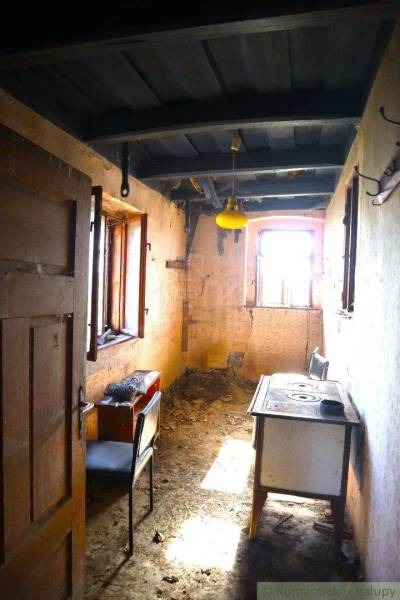 An abandoned family house with a simple kitchen and old appliances, it has a historical feel.
