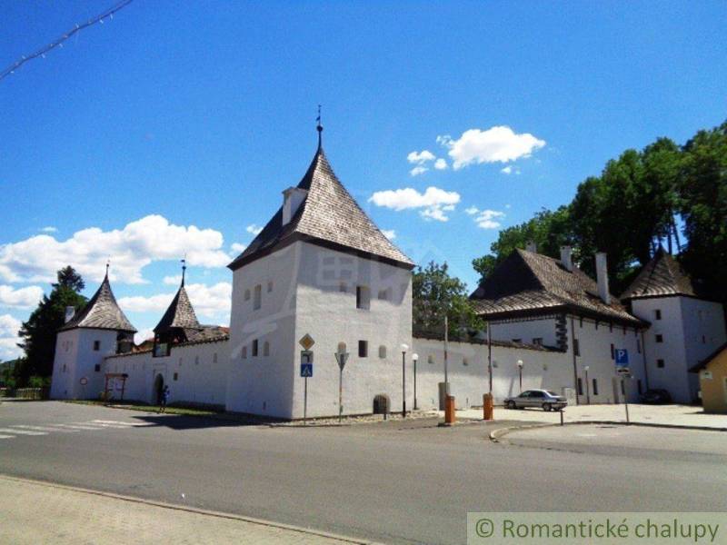 A historic building with towers on grounds in a picturesque location for living.