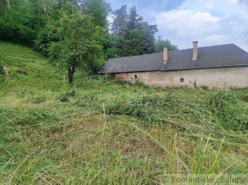 A rural building surrounded by grass and trees, ideal for living on large plots.