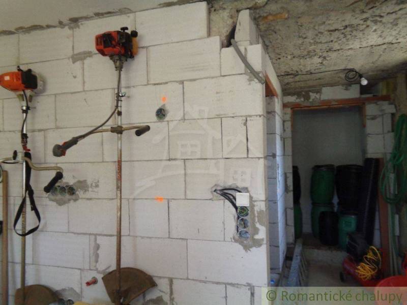 Unfurnished room in a family house, with garden tools and equipment on the wall.