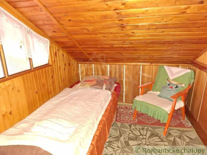A room in a cottage, wooden interior, bed, chair, cozy atmosphere.