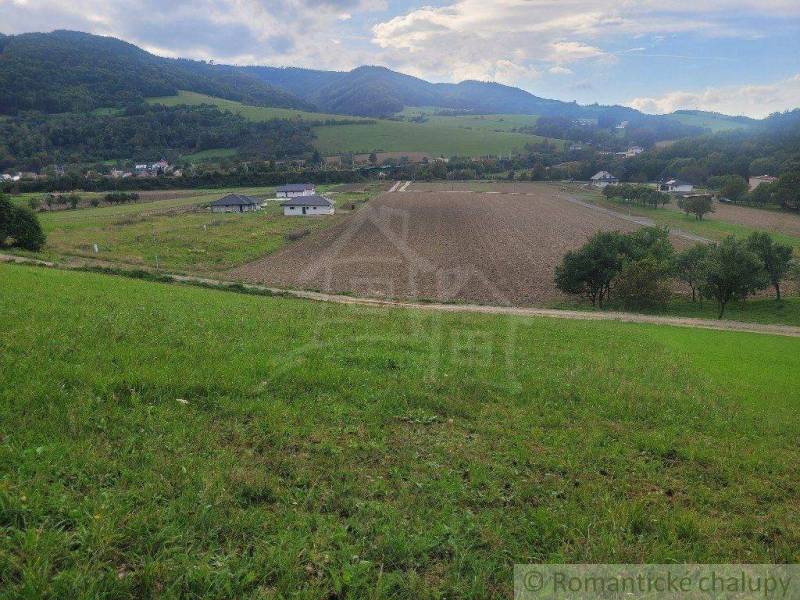 Idyllic landscape with fields surrounded by hills and gardens, peaceful atmosphere of nature.