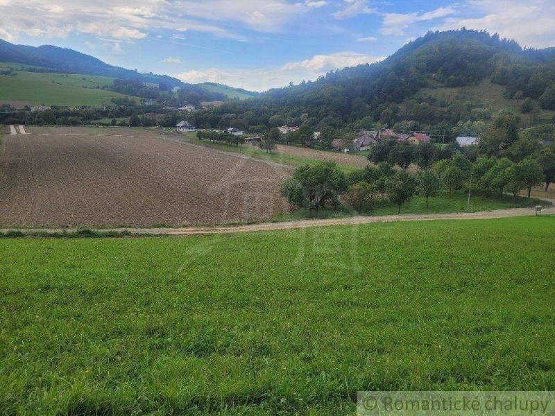 Grassy hills surround fertile fields in a peaceful rural setting near gardens.
