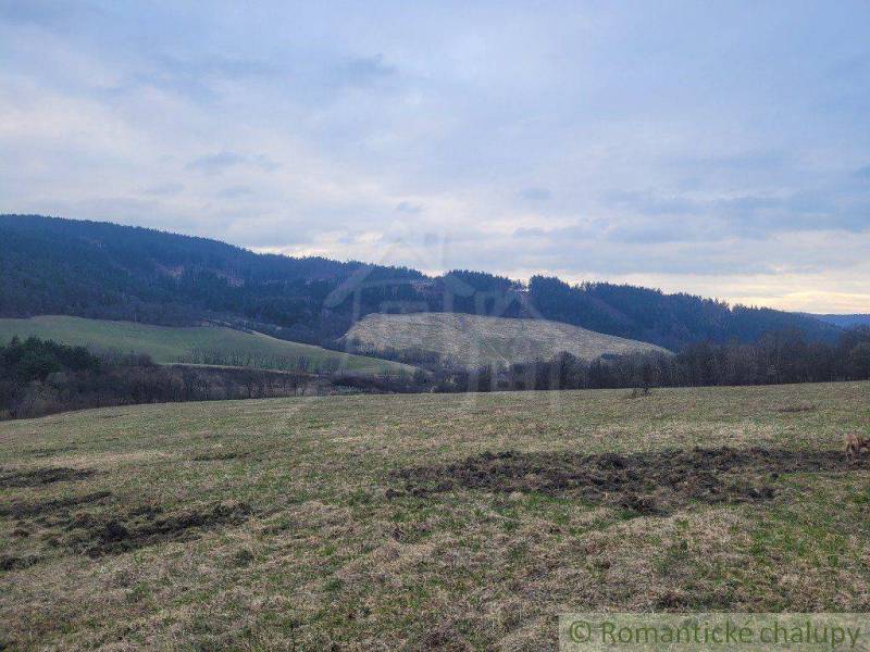 A vast meadow surrounded by hills, beautiful nature and tranquility, ideal for gardens.