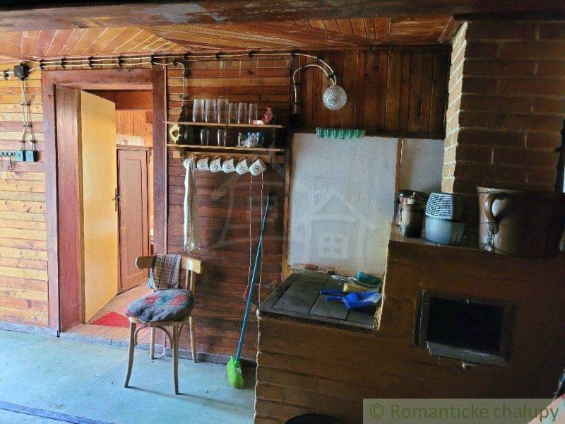Wooden interior with a stove, shelf, chair, and door in a family house.