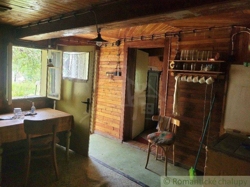 Rustic interior of a cottage with wood, a stool, a table, and glasses in a family house.