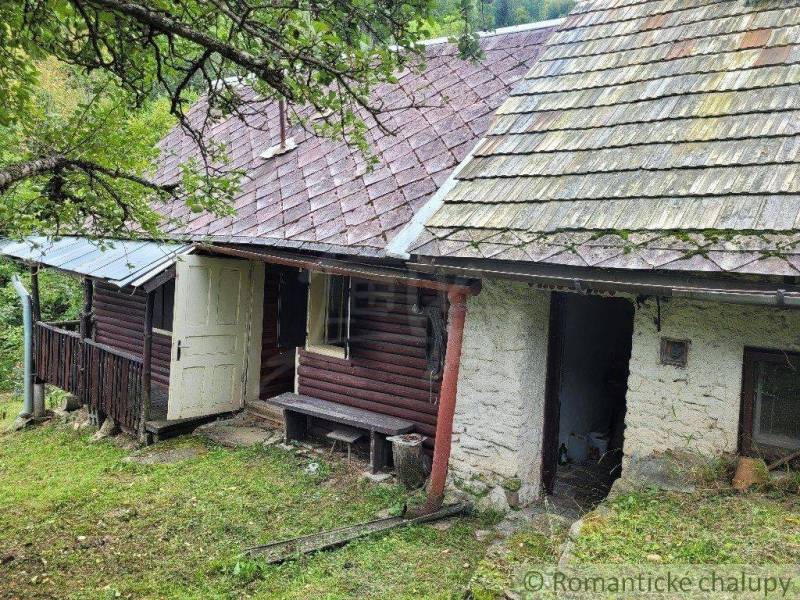 A family house with a wooden porch surrounded by nature, suitable for a peaceful country life.