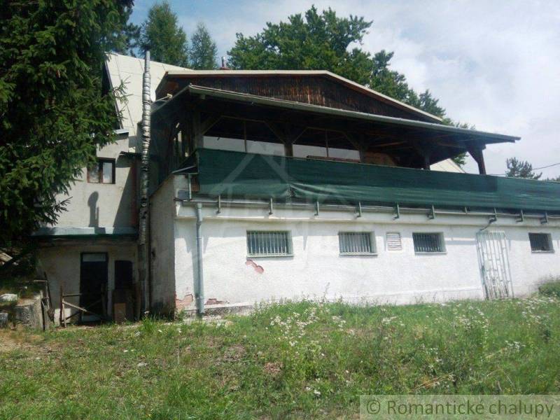 The picture shows an older cottage surrounded by nature, ideal for relaxation.