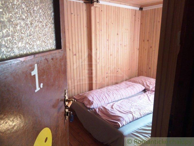 Wooden cabin; room with a bed and a door. Atmosphere of the cabin. Number one.